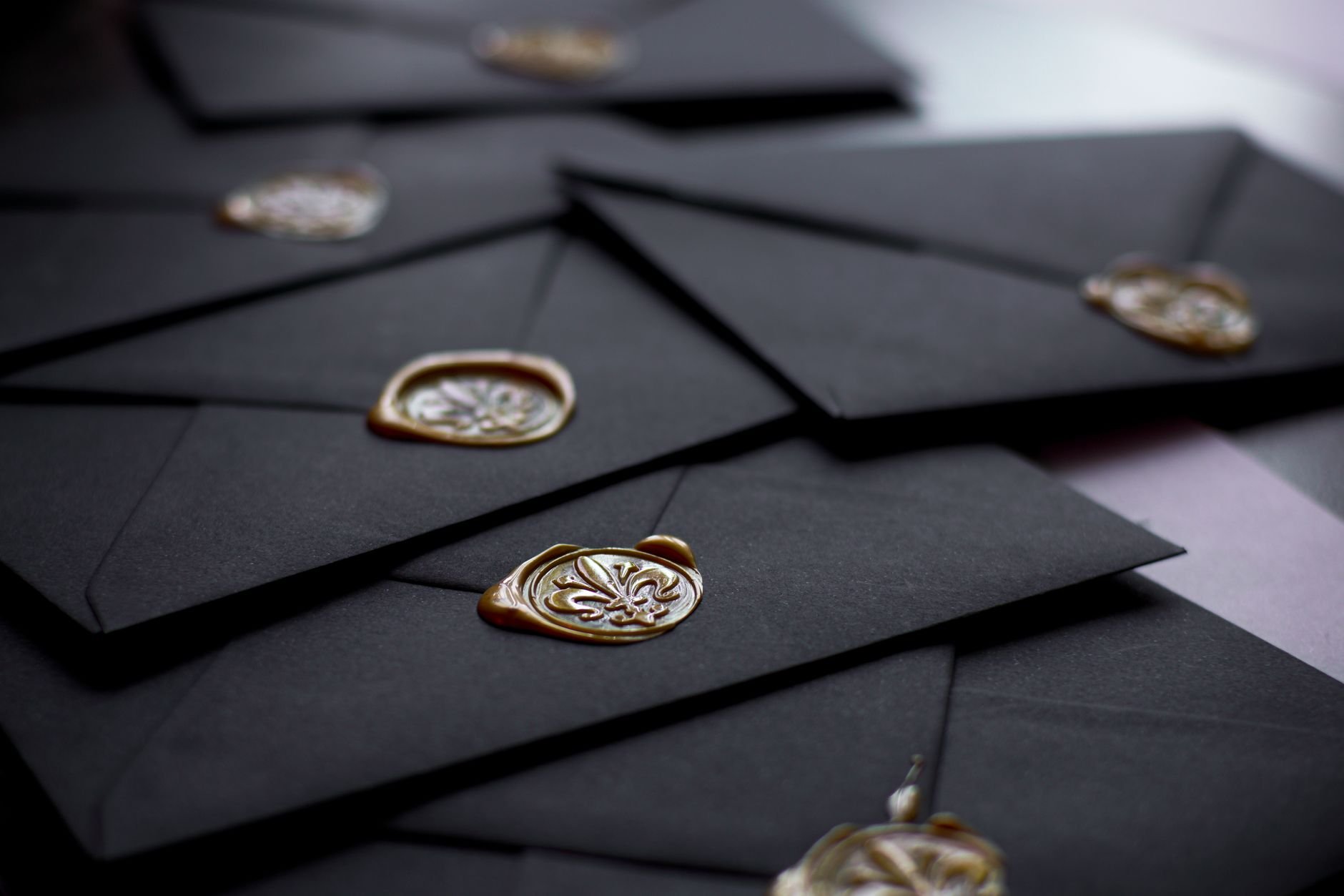 Close-up of black envelopes featuring vintage wax seals.